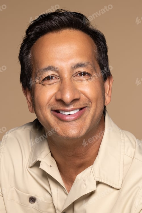 Preview: Studio Portrait Of Handsome Indian Man In His 50S Smiling On Neutral Background