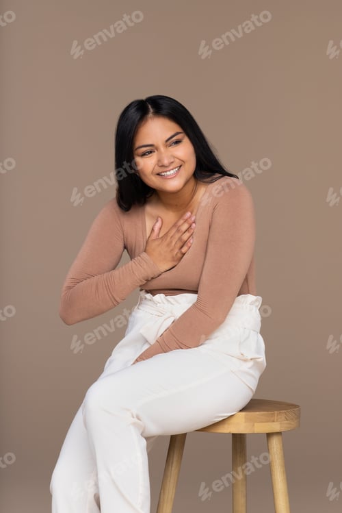 Preview: Studio Portrait Of A Southeast Asian Woman In Her 20'S Smiling With Her Hand On Her Heart.