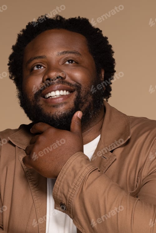 Preview: Portrait Of African American Man In His 30S Smiling Confidently And Posing With Hand On Chin On