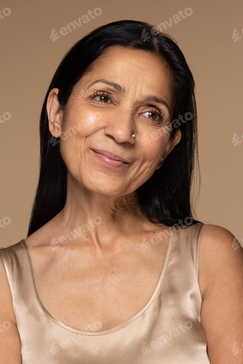 Preview: Portrait Of Beautiful East Indian Woman In Her 50S Smiling And Posing On Neutral Background