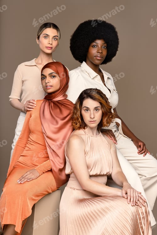 Vista previa: Foto de estudio de un grupo de hermosas mujeres multirraciales posando con confianza sobre un fondo neutro.