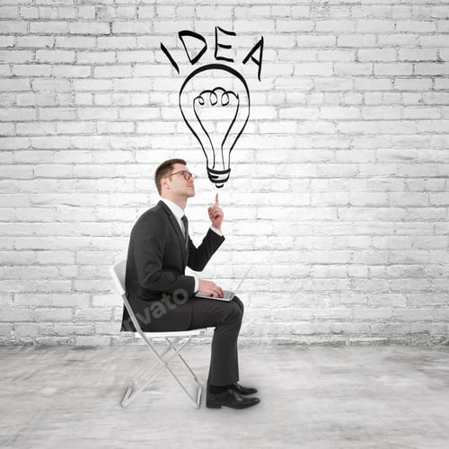 Preview: Businessman Sitting With Notebook And Pointing To Lightbulb