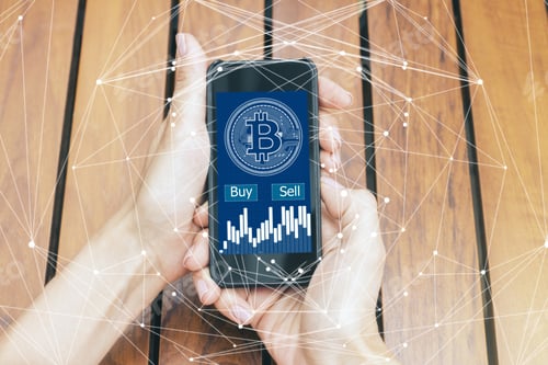 Preview: Hands Holding Smartphone With Bitcoin On Wooden Desk Background. E-Business And Payment Concept