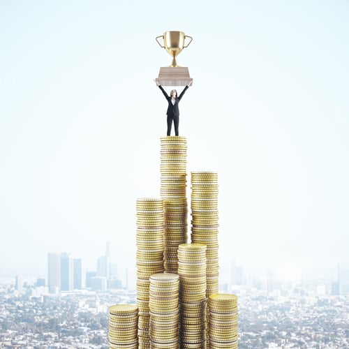 Preview: Businesswoman Standing On Stack Golden Coins And Holding Winner Cup On Panoramic City Background