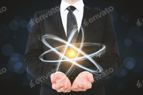 Preview: Businessman Holding Creative Atom On Blurry Dark Wallpaper. Medicine And Science Concept