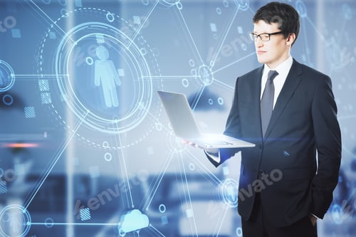 Preview: Attractive Young European Businessman With Laptop Standing In Office With Creative Glowing Blue