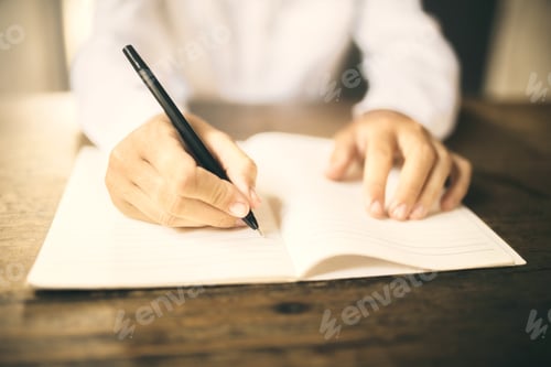 Preview: Man Writing With Pen In Blank Notebook On Wooden Table