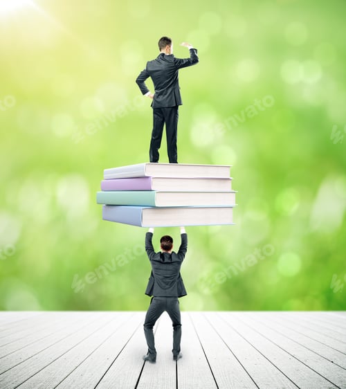 Preview: Businessmen Holding And Standing On Book Stack. Blurry Green Background. Education And Teamwork