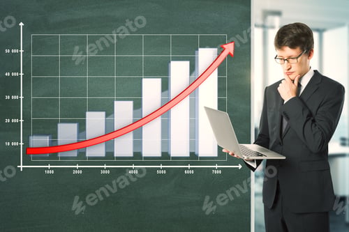 Preview: Attractive Young Businessman With Laptop Standing Next To Blackboard With Business Chart And Arrow