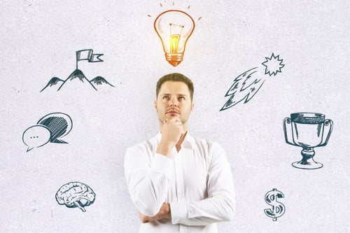 Preview: Handsome Caucasian Businessman Standing On Concrete Wall Background With Creative Lamp And Business