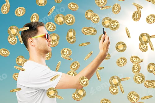 Preview: Young Businessman With Smartphone And Bitcoin Rain On Sky Background With Siunlight. Success And