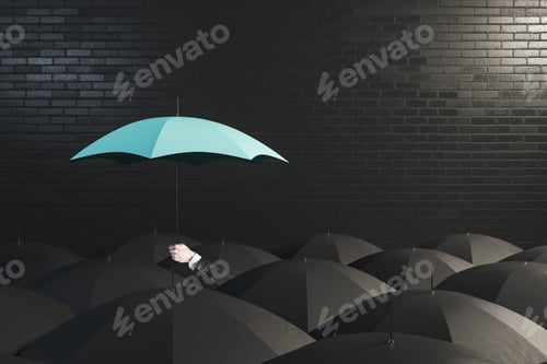 Preview: Hand Holding A Blue Umbrella On Top Of Other Umbrellas. Business And Safety Concept