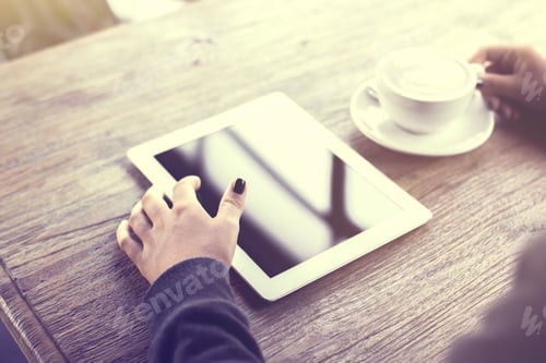 Preview: Girl Using Digital Tablet And A Cup Of Coffee On A Wooden Table