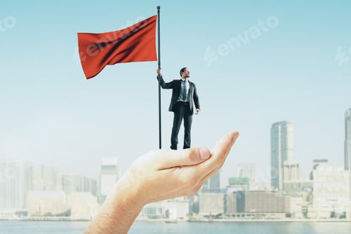 Preview: Abstract Hand Holding Businessman With Red Flag On Blurry New York City Background. Leadership And