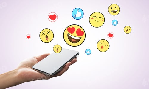 Preview: Hand Holding Smartphone With Emotive On Subtle Background. Communication And Emotion Concept