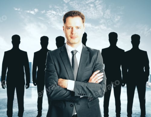 Preview: Leadership Concept With Handsome Caucasian Businessman In Front Of Businesspeople Silhouettes On