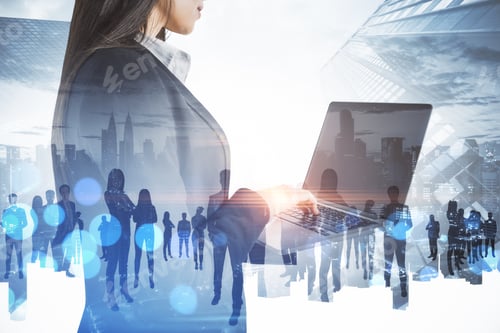 Preview: Businesswoman Using Laptop With Abstract Crowd Of Businesspeople Standing On Abstract Bright City