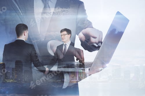 Preview: Attractive European Businessmen Using Laptop Together On Abstract City Background With Daylight