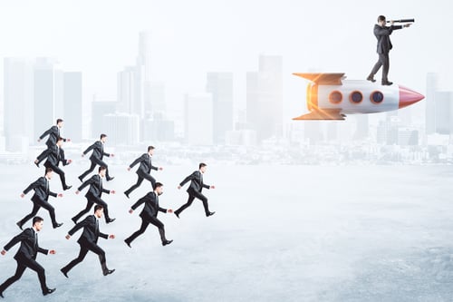 Preview: Men Following Businessman On Rocket Looking Into The Distance On Blurry City Background. Startup