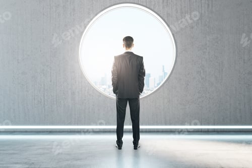 Preview: Back View Of Thoughtful Young Businessman Standing In Creative Modern Concrete Interior With Round