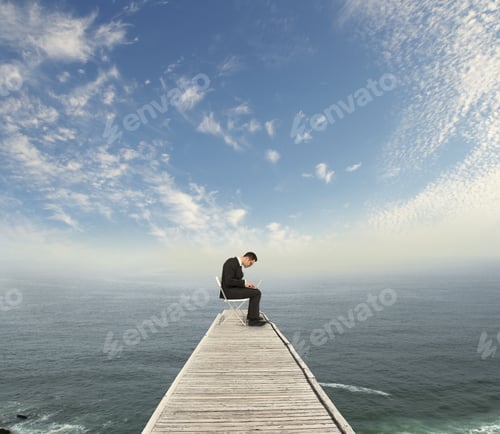 Preview: Businessman Sitting On Wooden Pier With Laptop