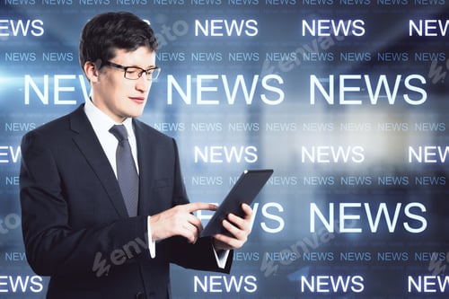 Preview: Attractive Young European Businessman Using Tablet In Blurry Office Interior With Glowing News