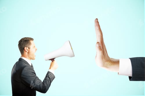 Preview: Irritated Young Man With Megaphone Screaming At Hand Showing Stop Gesture On Blue Background