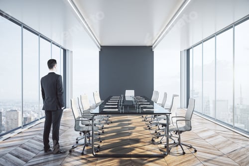 Preview: Businessman Standing In Clean Meeting Room Interior With City View And Daylight.
