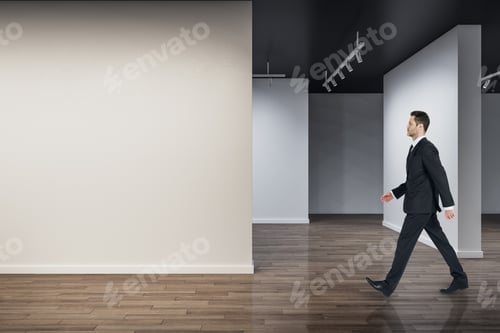 Preview: Businessman Walking In Modern Concrete Exhibition Hall Interior With Mock Up Place On Wall And