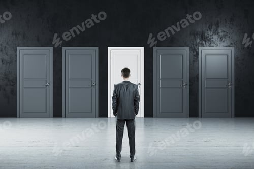 Preview: Businessman Standing In Gray Room And Looking On Five Closed Doors. Business And Challenge Concept.