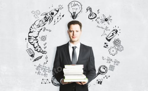 Preview: Handsome European Businessman With Books Standing On Concrete Wall Background With Business Sketch