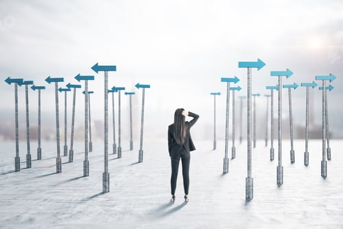Preview: Businessman In Suit Standing Back And Blue Arrows Pointers Around Him. Business And Challenge