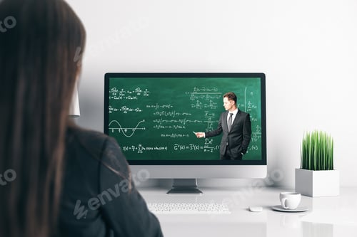 Preview: Young Businesswoman At Office Desk Looking At Computer Screen With Online Education Chalkboard And