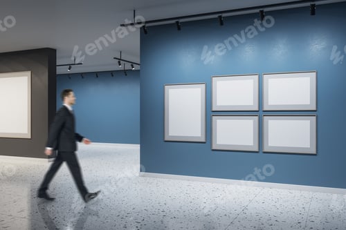Preview: Businessman Walking In Modern Concrete Exhibition Hall Interior With Empty White Mock Up Posters On