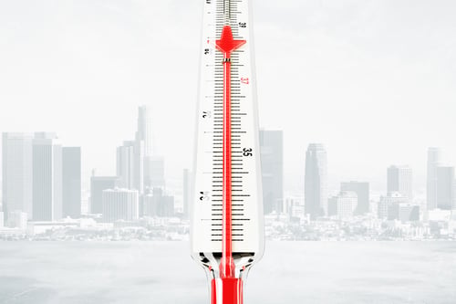 Preview: Thermometer With Red Mercury Downward Arrow At City Background