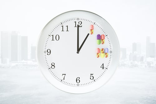 Preview: Receiving Medication On A Schedule Concept With Wall Clock And Pills At City Background