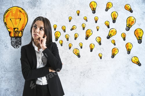 Preview: Attractive Young European Businesswoman With Creative Lamps Sketch On Concrete Wall. Brainstorm And