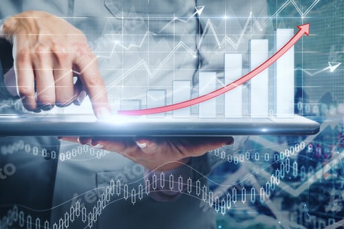 Preview: Close Up Of Hand Using Tablet With Business Chart Hologram On Blurry Office Interior Background