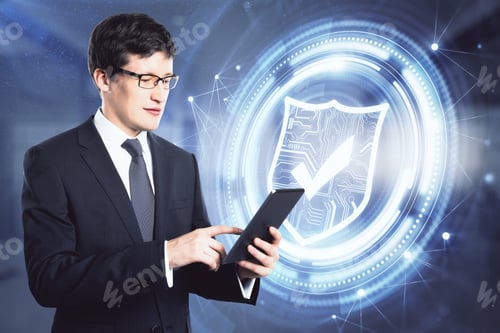 Preview: Attractive Young European Businessman With Tablet Standing In Blurry Office Interior With Glowing