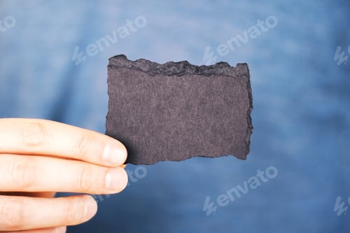Preview: Hand Holding Blank Crafted Business Card With Uneven Edges On Blue Background. Mock Up