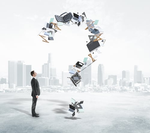 Preview: Businessman Looking At Abstract Question Mark Made Of Office Tools And Items On Foggy City