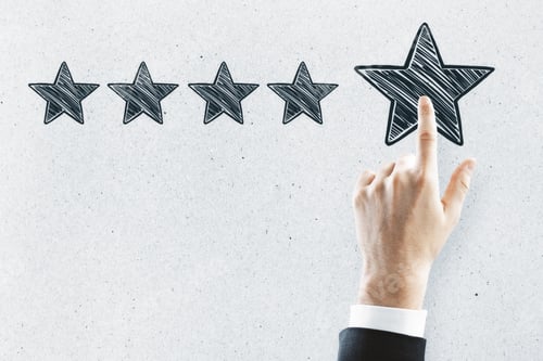 Preview: Businessman Pointing At Abstract Stars On Concrete Wall Background. Experience Rating And