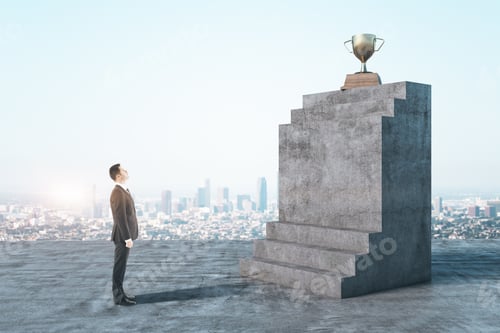 Preview: Businessman In Suit Looking On Abstract Concrete Stairs With Gold Winners Cup On City Background