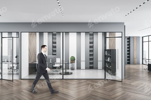 Preview: Businessman Walking In Modern Concrete Glass Office Interior With Daylight, Equipment And Wooden