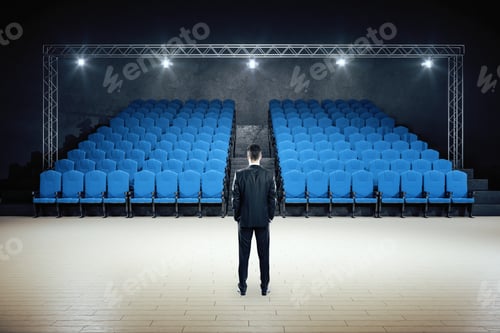 Preview: Businessman Standing In Minimalistic Movie Theater With Blue Chairs. Cinema And Entertainment