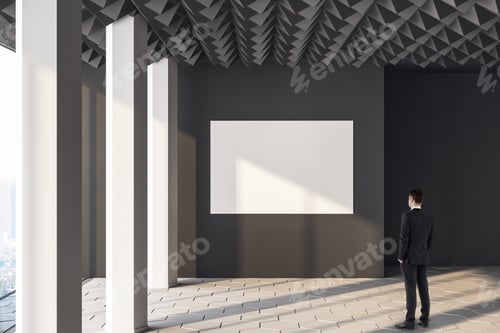 Preview: Businessman Looking On Blank Poster On Wall In Minimalistic Concrete Interior Room. Presentation