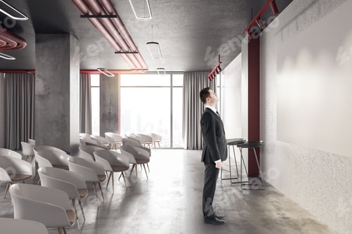 Preview: Businessman Looking On Blank Screen In Presentation Room With White Chairs. Conference And