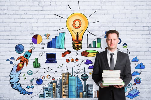 Preview: Businessman Holding Books On White Brick Wall Background With Business Sketch. Education, Idea And
