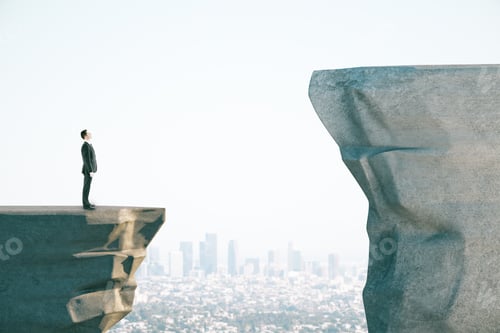 Preview: Businessman In Suit On Cliff Looking Into Distance On Blue Sky Background With City Skyline