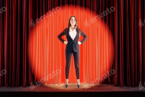 Preview: Attractive Businesswoman Standing On Red Stage In Spotlighting. Star, Show, Speech And Presentation
